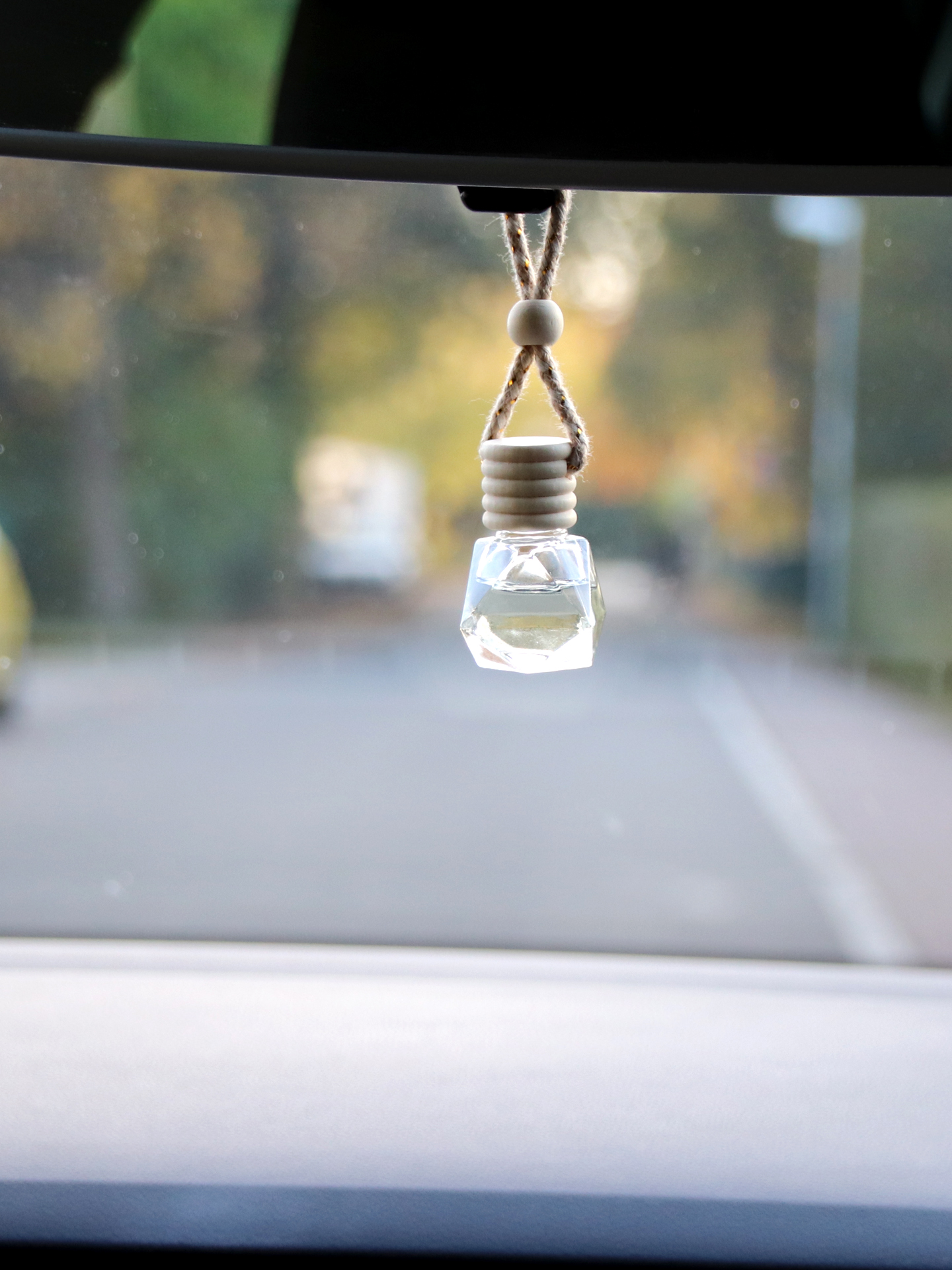 ein kristallförmiger Anhänger gefüllt mit Öl hängt an einem Auto-Rückspiegel